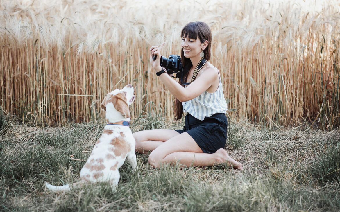 Frau fotografiert Hund in der Natur