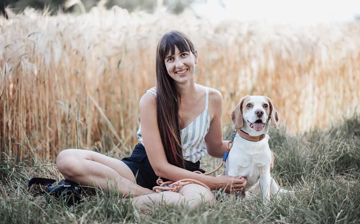 Junge Frau mit Hund in der Natur sitzend